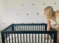 A woman makes a baby bed crib black with white background and polka dots interior design A woman makes a baby bed crib black with white background and polka dots interior design - PhotoDune Item for Sale