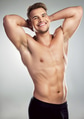 Studio portrait of a muscular young man posing against a grey background Studio portrait of a muscular young man posing against a grey background - PhotoDune Item for Sale