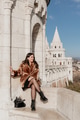 Portrait of stylish young woman sitting on walls of Fisherman's bastion in Budapest, Hungary Portrait of stylish young woman sitting on walls of Fisherman's bastion in Budapest, Hungary - PhotoDune Item for Sale