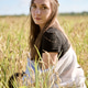 Young woman sitting in sunlit rye field during daytime Young woman sitting in sunlit rye field during daytime - PhotoDune Item for Sale