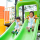 Asian girl and boy siblings having fun playing on colorful climbing slides in the park's playground. Asian girl and boy siblings having fun playing on colorful climbing slides in the park's playground. - PhotoDune Item for Sale