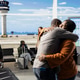 Loving travelers embracing in airport lounge area before boarding plane Loving travelers embracing in airport lounge area before boarding plane - PhotoDune Item for Sale