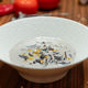 Mushroom soup served in a textured white bowl on a wooden table in a restaurant setting Mushroom soup served in a textured white bowl on a wooden table in a restaurant setting - PhotoDune Item for Sale