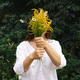 A woman holds a bouquet of wild flowers in her hands, covering her face with it, impersonal. A woman holds a bouquet of wild flowers in her hands, covering her face with it, impersonal. - PhotoDune Item for Sale