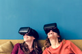 Two caucasian woman using VR on a sofa Two caucasian woman using VR on a sofa - PhotoDune Item for Sale