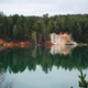 Beautiful blue lake and red clay cliffs in a forest reflecting in a water Beautiful blue lake and red clay cliffs in a forest reflecting in a water - PhotoDune Item for Sale