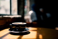A cup of coffee near window with shadow A cup of coffee near window with shadow - PhotoDune Item for Sale