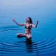 Woman sitting cross-legged on water with ripples in serene setting. WA, USA Woman sitting cross-legged on water with ripples in serene setting. WA, USA - PhotoDune Item for Sale