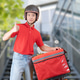 Cheerful young delivery man stands casually beside a red motorcycle Cheerful young delivery man stands casually beside a red motorcycle - PhotoDune Item for Sale