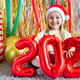 Smiling young girl in Santa hat holding 2026 balloons during festive celebration Smiling young girl in Santa hat holding 2026 balloons during festive celebration - PhotoDune Item for Sale