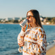 Young beautiful woman in cozy sweater and sunglasses enjoying hot coffee from thermo mug while Young beautiful woman in cozy sweater and sunglasses enjoying hot coffee from thermo mug while - PhotoDune Item for Sale