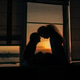 Two sisters are sitting on the windowsill and talking to each other. Silhouettes, sunset light Two sisters are sitting on the windowsill and talking to each other. Silhouettes, sunset light - PhotoDune Item for Sale