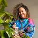 Happy brazilian woman watering her monstera plant at home Happy brazilian woman watering her monstera plant at home - PhotoDune Item for Sale
