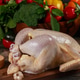 Fresh whole chicken prepared on wooden cutting board with vibrant vegetables in background Fresh whole chicken prepared on wooden cutting board with vibrant vegetables in background - PhotoDune Item for Sale