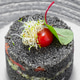 Fresh food dish made with black ingredients and garnished with a cherry tomato Fresh food dish made with black ingredients and garnished with a cherry tomato - PhotoDune Item for Sale