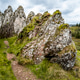 Rugged rocky terrain with moss and a winding dirt path under a cloudy sky. Rugged rocky terrain with moss and a winding dirt path under a cloudy sky. - PhotoDune Item for Sale