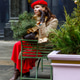 A woman in a red clothes with a bouquet of fir branches walks along the Christmas decorated streets A woman in a red clothes with a bouquet of fir branches walks along the Christmas decorated streets - PhotoDune Item for Sale
