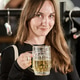 Young woman holding beer mug and smiling in cozy bar setting Young woman holding beer mug and smiling in cozy bar setting - PhotoDune Item for Sale