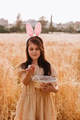 Preteen girl in wheat field with easter bunny ears holding basket collecting eggs Preteen girl in wheat field with easter bunny ears holding basket collecting eggs - PhotoDune Item for Sale