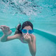 Young girl with dark hair wearing blue goggles is swimming underwater in a clear pool Young girl with dark hair wearing blue goggles is swimming underwater in a clear pool - PhotoDune Item for Sale