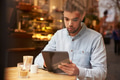 Man Viewed Through Window Of Caf‚ Using Digital Tablet Man Viewed Through Window Of Caf‚ Using Digital Tablet - PhotoDune Item for Sale