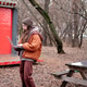 female freelancer in a brown jacket works standing with a laptop in an autumn park female freelancer in a brown jacket works standing with a laptop in an autumn park - PhotoDune Item for Sale
