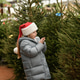 Small girl chooses a Christmas tree in the market and pricked herself with the needles Small girl chooses a Christmas tree in the market and pricked herself with the needles - PhotoDune Item for Sale