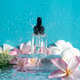 Moisturizing serum surrounded by plumeria flowers under refreshing splashes of water Moisturizing serum surrounded by plumeria flowers under refreshing splashes of water - PhotoDune Item for Sale