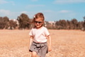 Little girl walking alone in field with yelllow grass. Scenic countryside life, unity with nature Little girl walking alone in field with yelllow grass. Scenic countryside life, unity with nature - PhotoDune Item for Sale