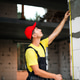 Construction worker checks vertical height of window opening, Construction worker checks vertical height of window opening, - PhotoDune Item for Sale
