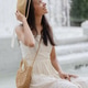 young African American woman in white dress and straw hat sits by white marble fountain. young African American woman in white dress and straw hat sits by white marble fountain. - PhotoDune Item for Sale