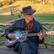 A seasoned musician plays the blues on a park bench in the fall. A seasoned musician plays the blues on a park bench in the fall. - PhotoDune Item for Sale