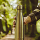 Close-up of Unrecognizable female hand holding Water bottle. Reusable steel thermo Close-up of Unrecognizable female hand holding Water bottle. Reusable steel thermo - PhotoDune Item for Sale