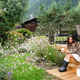 Young woman in rubber boots sitting on wooden porch steps in her blooming summer garden Young woman in rubber boots sitting on wooden porch steps in her blooming summer garden - PhotoDune Item for Sale