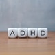 Four white cubes spelling out ADHD on a wooden table. Four white cubes spelling out ADHD on a wooden table. - PhotoDune Item for Sale