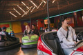 Friends having fun on bumper cars in amusement park Friends having fun on bumper cars in amusement park - PhotoDune Item for Sale