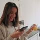 Woman Using Phone at Home with Orange Juice Woman Using Phone at Home with Orange Juice - PhotoDune Item for Sale