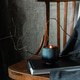Lit candle in ceramic cup on notebook with wooden chair and gray fabric Lit candle in ceramic cup on notebook with wooden chair and gray fabric - PhotoDune Item for Sale
