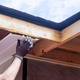 Worker installing soffit under eaves on residential building during works day Worker installing soffit under eaves on residential building during works day - PhotoDune Item for Sale