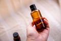 Hand holding amber glass bottles on natural background Hand holding amber glass bottles on natural background - PhotoDune Item for Sale