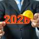 The official holds the year 2026 and a yellow worker's helmet. Plans for next year. Construction The official holds the year 2026 and a yellow worker's helmet. Plans for next year. Construction - PhotoDune Item for Sale