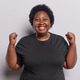 Excited cheerful obese dark skinned woman with curly hair dressed in casual black tshirt clenches Excited cheerful obese dark skinned woman with curly hair dressed in casual black tshirt clenches - PhotoDune Item for Sale