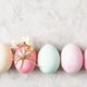 Pastel Easter eggs and spring flowers on light grey background, copy space. Pastel Easter eggs and spring flowers on light grey background, copy space. - PhotoDune Item for Sale