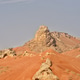 Rocky arid red sand desert mountains and rock formations in mid summer afternoon natural sunlight Rocky arid red sand desert mountains and rock formations in mid summer afternoon natural sunlight - PhotoDune Item for Sale