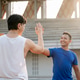 Asian man is giving high five to his friend in the sports stadium. Outdoor exercise or training. Asian man is giving high five to his friend in the sports stadium. Outdoor exercise or training. - PhotoDune Item for Sale