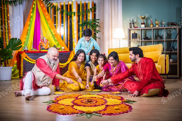 Indian family bonding over creating rangoli during Diwali or Ganesh festival celebration Stock Photo by stockimagefactory