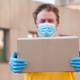 middle-aged man in a medical mask and gloves delivers a cardboard box with the ordered products middle-aged man in a medical mask and gloves delivers a cardboard box with the ordered products - PhotoDune Item for Sale