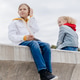 Two schoolmates relax and have fun on concrete embankment. Two schoolmates relax and have fun on concrete embankment. - PhotoDune Item for Sale