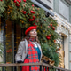 A woman in a red clothes with a bouquet of fir branches walks along the Christmas decorated streets A woman in a red clothes with a bouquet of fir branches walks along the Christmas decorated streets - PhotoDune Item for Sale