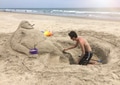 People at the beach. Young adult making a sand sculpture at the beach for a sand sculpture contest. People at the beach. Young adult making a sand sculpture at the beach for a sand sculpture contest. - PhotoDune Item for Sale